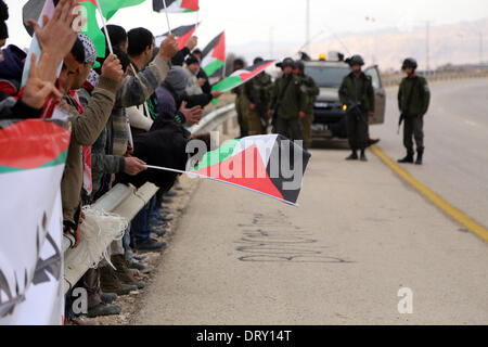 Jordan Vally, Westjordanland, Palästinensische Gebiete. 4. Februar 2014. Israelische Soldaten zu sehen, als Palästinenser und ausländische Aktivisten halten palästinensische Fahnen während einer Protestaktion an der Stelle des alten Dorfes als Ein Hijleh im Jordan-Tal in der Nähe der West Bank Stadt Jericho 4. Februar 2014 bekannt. Israelische Truppen überfallen Ortsbild Ein Hijleh Dorf, die Aktivisten zu evakuieren, die die Melh Al-Ard (Salz der Erde)-Kampagne ins Leben gerufen durch die Wiederbelebung des Dorfes auf dem Gelände der orthodoxen Kirche und St. Credit: ZUMA Press, Inc./Alamy Live News Stockfoto