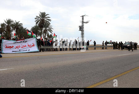 Jordan Vally, Westjordanland, Palästinensische Gebiete. 4. Februar 2014. Israelische Soldaten zu sehen, als Palästinenser und ausländische Aktivisten halten palästinensische Fahnen während einer Protestaktion an der Stelle des alten Dorfes als Ein Hijleh im Jordan-Tal in der Nähe der West Bank Stadt Jericho 4. Februar 2014 bekannt. Israelische Truppen überfallen Ortsbild Ein Hijleh Dorf, die Aktivisten zu evakuieren, die die Melh Al-Ard (Salz der Erde)-Kampagne ins Leben gerufen durch die Wiederbelebung des Dorfes auf dem Gelände der orthodoxen Kirche und St. Credit: ZUMA Press, Inc./Alamy Live News Stockfoto