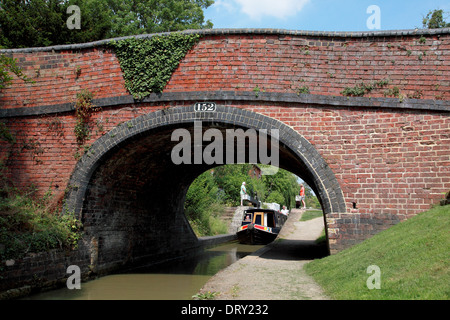 Ein Narrowboat Cropredy Schleuse verlassen und gehen unter Cropredy Schleusenbrücke am Oxford-Kanal in Cropredy, Oxfordshire Stockfoto