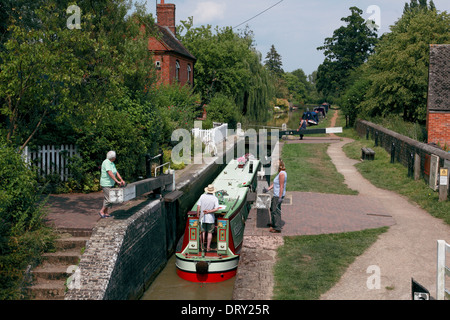 Ein Narrowboat Eingabe Cropredy Lock und gehen unter Cropredy Schleusenbrücke am Oxford-Kanal in Cropredy, Oxfordshire Stockfoto