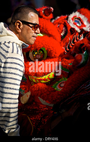 Mann steht neben einem Drachen in Chinatown Los Angeles früh am chinesischen Neujahrstag. Stockfoto