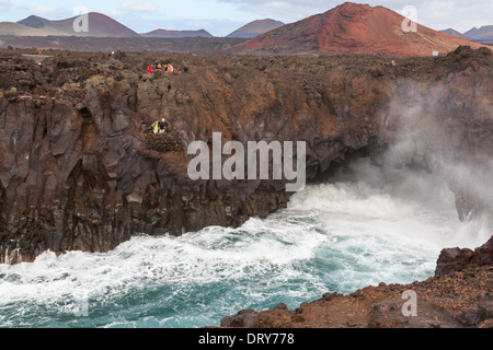 Touristen auf eine Aussichtsplattform auf dem Seeweg eine Höhle in Lava Felsen im Costa Los Hervideros. El Golfo, Lanzarote, Kanarische Inseln, Spanien Stockfoto