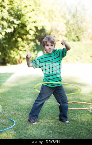 Jungen spielen mit Hula Hoops in Hof Stockfoto