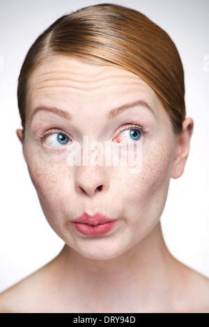 Junge Frau, die Lippen spitzte Stockfoto