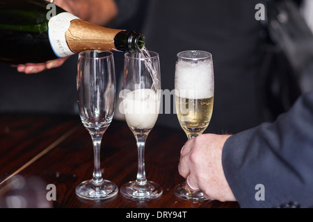 Gießen Sie Champagner an einer Abendessen-Partei-Close-Up-Ansicht Stockfoto