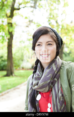 Junge Frau lächelnd in Park, Porträt Stockfoto