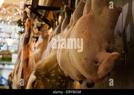 Ungedeckte Puten hängen vor einem Metzger-Shop in Oxford überdachte Markt. Stockfoto