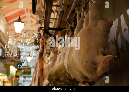 Ungedeckte Puten hängen vor einem Metzger-Shop in Oxford überdachte Markt. Stockfoto