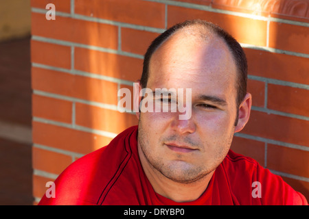 Nahaufnahme eines Jünglings nachdenklich über Ziegelmauer. Stockfoto