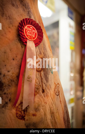 Eine Kuh-Karkasse (Rindfleisch Steuern) fotografiert Nahaufnahme hängenden vor einem Metzger-Geschäft, eine ersten Preis Rosette ist darauf fixiert. Stockfoto