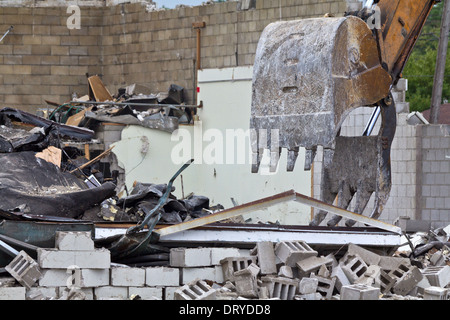 Bagger hat ein abgerissenes Gebäude in der Stadt. Bagger mit Baggerlader-Abbruchbagger lädt Schutt von der Wand ein Haus von vorne niemand Hi-res Stockfoto