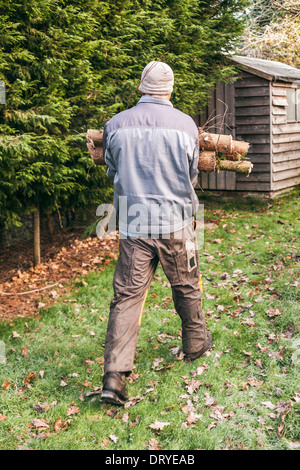 Gärtner mit Holz im Garten. Stockfoto