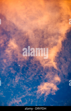 Mondsichel und dramatische rosa und orange Wolken bei Sonnenuntergang, Salida, Colorado, USA Stockfoto