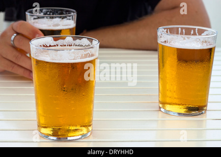 Nahaufnahme von Gläser frisches Bier und die Hände auf den Tisch. Stockfoto