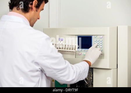 Wissenschaftler mit Proben Analyzer im Labor in Betrieb Stockfoto