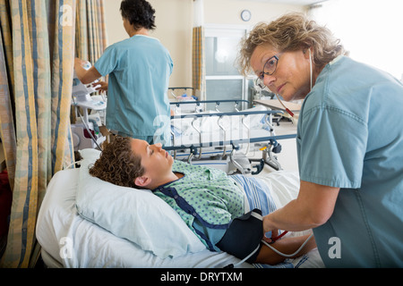 Krankenschwester Blutdruck überprüfen Patienten Stockfoto