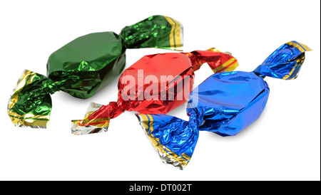 Drei Pralinen mit Wrapper in verschiedenen Farben auf weißem Hintergrund Stockfoto
