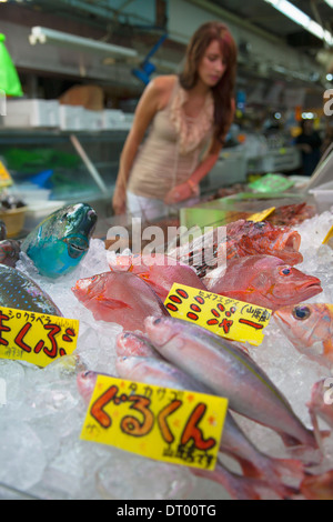 Frau, die auf Fisch und Meeresfrüchte in Makishi Markthalle, Naha, Okinawa, Japan Stockfoto