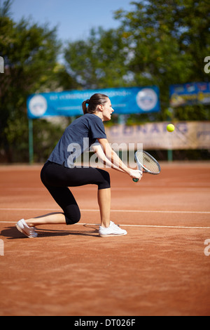 Tennisspielerin Ausführung einen Rückhand volley Stockfoto