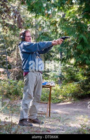 Amerikanische Männer schießen auf Bäume für Zielübungen in Okanogan-Wenatchee National Forest, Washington State, USA, 2012 Stockfoto