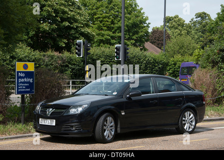 Schwarzes Auto parkte vor keine Parkplatz-Schild Stockfoto