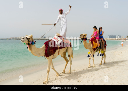 Touristen, die Einnahme von einem Kamel reiten am Strand bei Marina Bezirk des neuen Dubai in Vereinigte Arabische Emirate Stockfoto