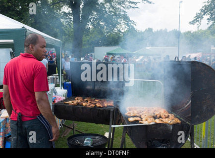 Schwarze afrikanische Karibik Mann Kochen Ruckhuhn an Karneval. Stockfoto