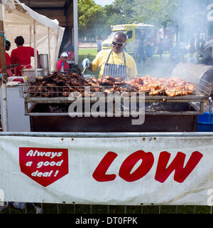 Schwarze afrikanische Karibik Mann Kochen Ruckhuhn an Karneval. Stockfoto