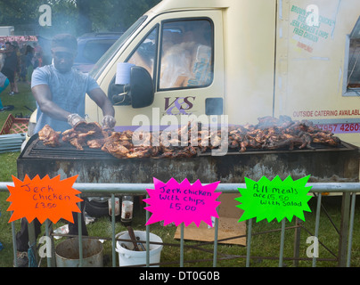 Schwarze afrikanische Karibik Mann Kochen Ruckhuhn an Karneval. Stockfoto