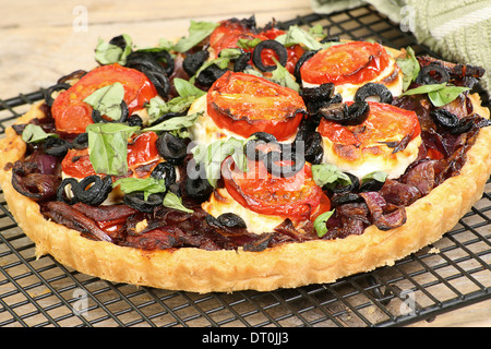 Caramalised Zwiebel und Ziegen Käse-Tarte mit Tomaten und Oliven Stockfoto