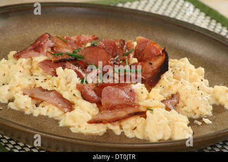 knusprigem Speck Stücke auf einem Bett von Rührei Stockfoto