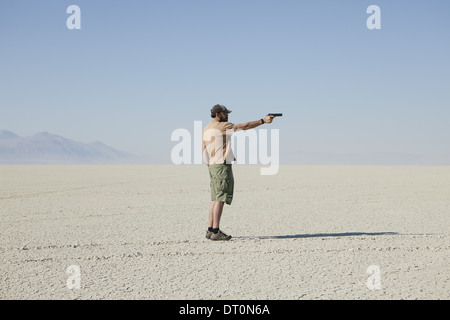 Black Rock Wüste Nevada USA Mann mit dem Ziel Hand Pistole Stellung in öden Wüste Stockfoto