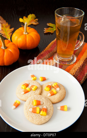 Teller mit Süßigkeiten Mais Cookies mit einer Tasse Tee, Kürbisse und bunte Herbst Blätter Stockfoto