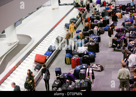 Reisende warten auf einem Flughafen auf dem Gepäckband. Stockfoto