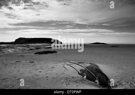 Umgedrehten Boot vergraben im Sand am Strand mit Hügeln in der Ferne Stockfoto