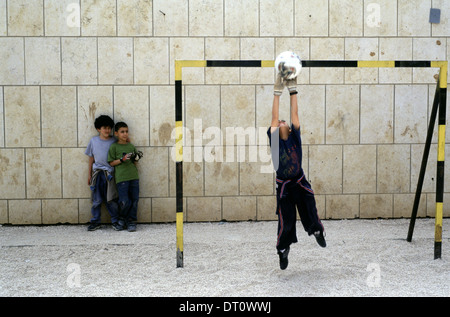 Junge israelische jüdische und arabische Kinder Fußball spielen auf dem Spielplatz im Innenhof der 'Hand in Hand' integriert, zweisprachige Hebrew-Arabic Schule für jüdische und arabische Kinder in Jerusalem Israel Stockfoto