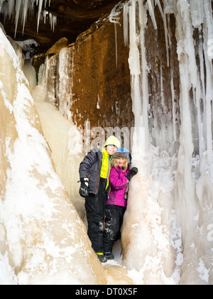 Bruder und Schwester stehen in einem kleinen Eishöhle an den Apostel Insel Eishöhlen, Makwike Bay, nahe Bayfield, Wisconsin, an einem kalten Stockfoto