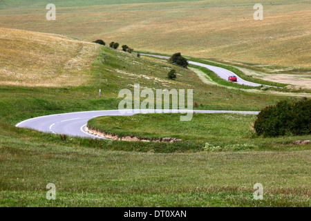 Rotes Auto fahren auf kurvenreichen Straße in South Downs in der Nähe von Beachy Head, in der Nähe von Eastbourne, East Sussex, England Stockfoto