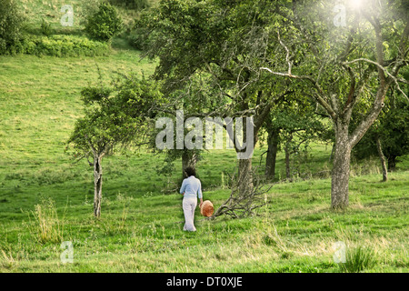 Junge Frau im Obstgarten im Sommer Stockfoto