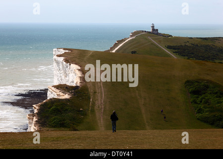 Wanderer zu Fuß entlang der South Downs Way Küstenpfad von Beachy Head in Richtung Belle Tout Leuchtturm, East Sussex, England Stockfoto