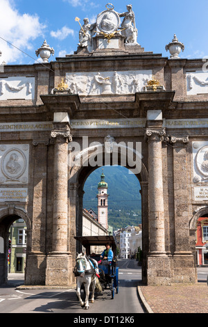 Touristen in Kutsche übergeben, Triumphbogen und Spitalskirche in Innsbruck, Tyrol, Österreich Stockfoto