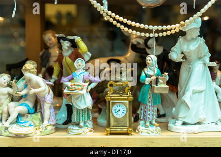 Porzellanfiguren und Uhr auf dem Display an Bordhin Antiquitätengeschäft in der Burgstraße in München, Bayern, Deutschland Stockfoto