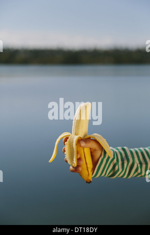 Seattle Washington USA neun Jahre alten Mädchen hält Bio geschälte Banane Stockfoto