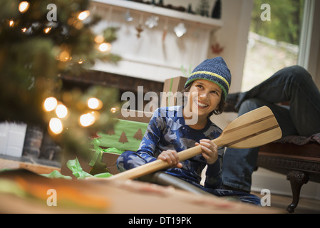 Woodstock, New York USA Boy von Weihnachtsbaum Auspacken Geschenk hölzerne Ruder Stockfoto