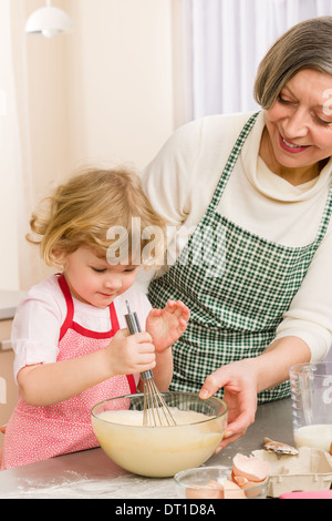 Großmutter und Enkelin verquirlen Teig Stockfoto