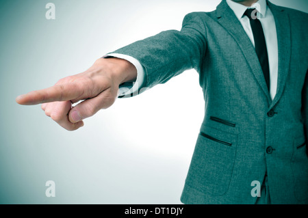 ein Mann in einem Anzug zeigen mit dem Finger den Weg nach draußen Stockfoto