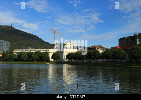 Blick über den See, Lille Lungegårdsvannet, Richtung Mount Ulriken und einem großen Kran in Bergen City, Norwegen, während ein Sommerabend. Stockfoto