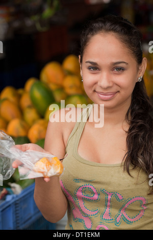 Costa Rica junge Frau Markt Standinhaber Verpackungsverordnung für einen Kunden. Stockfoto