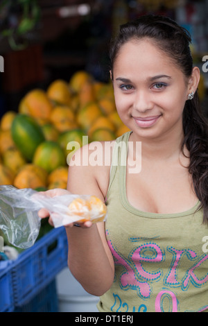 Costa Rica junge Frau Markt Standinhaber Verpackungsverordnung für einen Kunden. Stockfoto