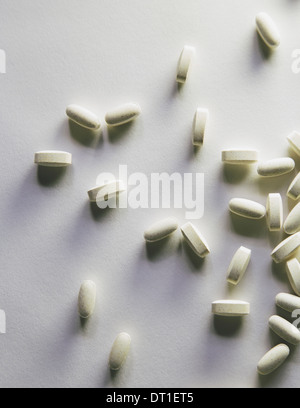 Vitamin C Ergänzungen weiße ovale Tabletten verteilt auf weißem Hintergrund Stockfoto